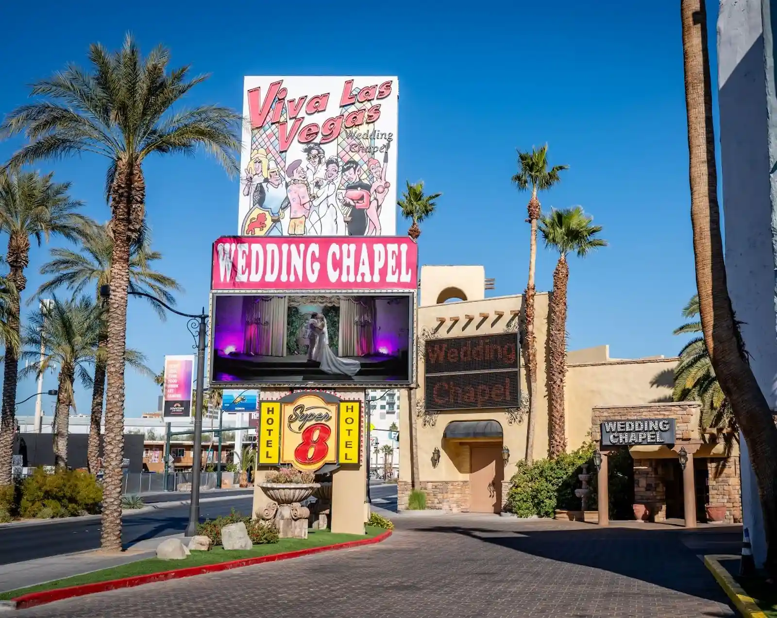 Viva Las Vegas Wedding Chapel exterior with colorful billboard sign and palm trees on Las Vegas Boulevard