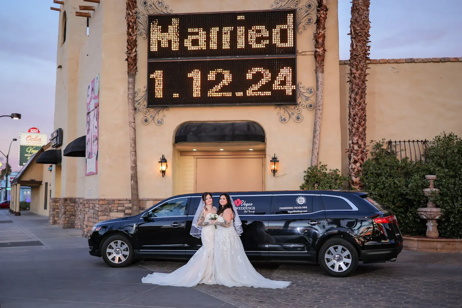 Two brides posing with wedding limo outside Viva Las Vegas Wedding Chapel under the Married marquee sign