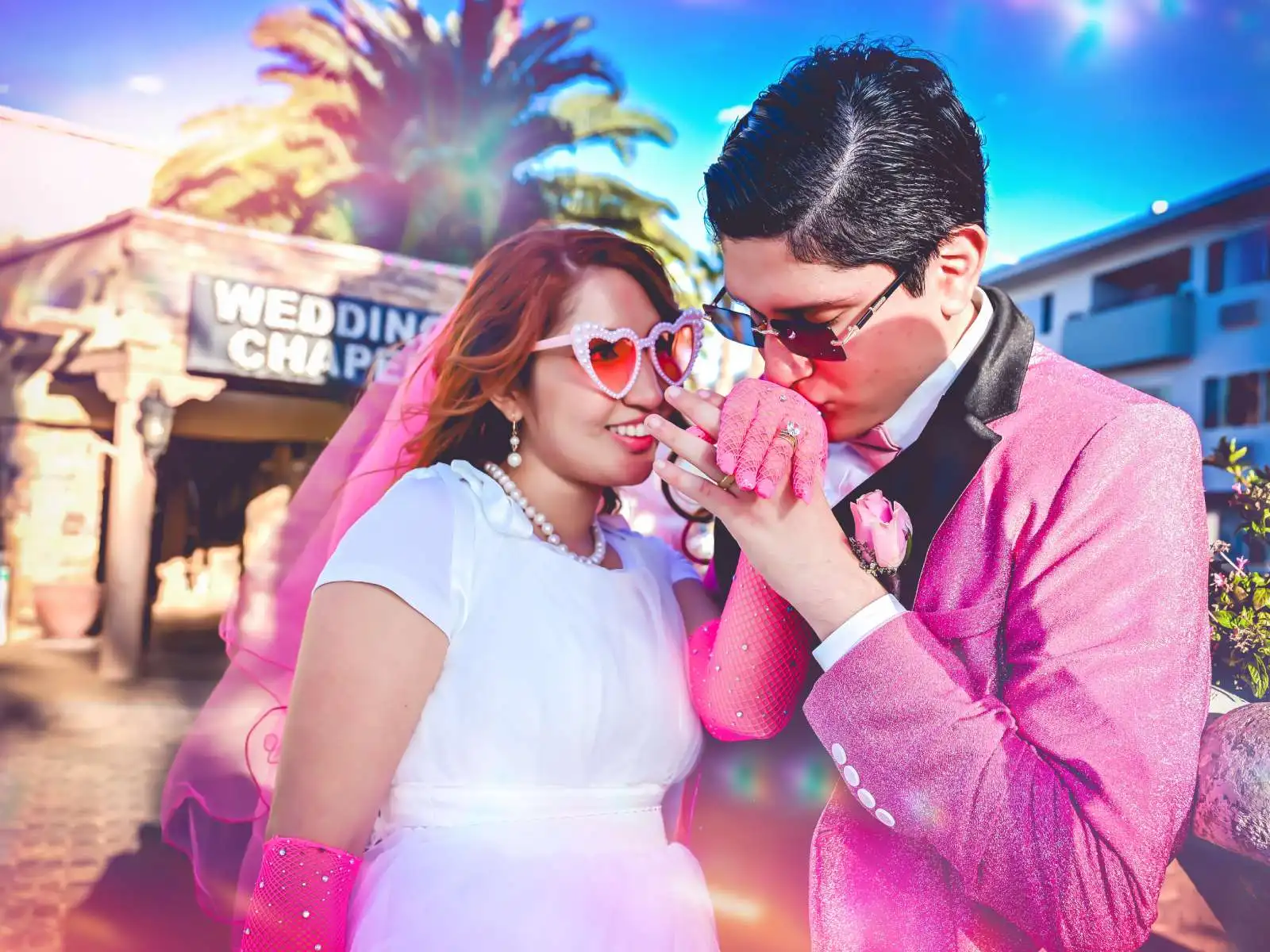 Groom in pink jacket kissing bride