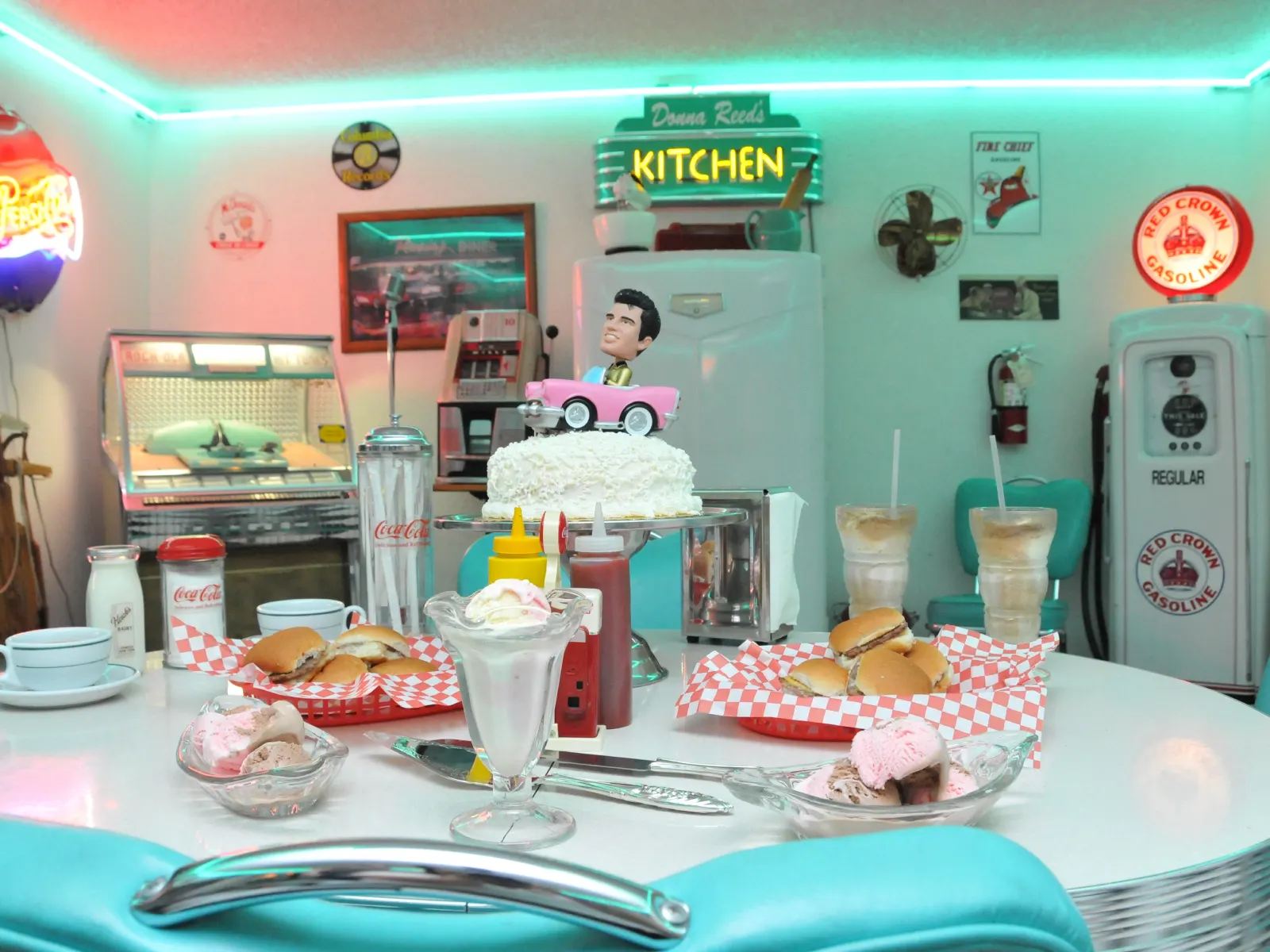 Wedding cake with pink Cadillac topper, sliders, milkshakes, and ice cream in 50s diner at Las Vegas chapel