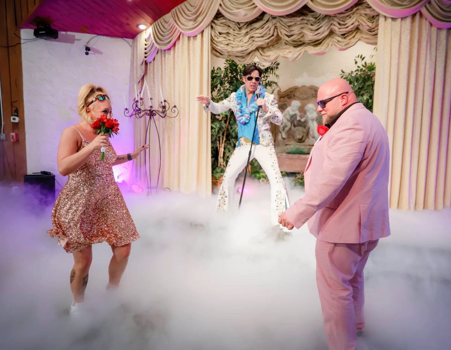 Bride and groom dancing in fog while Elvis impersonator performs during fun chapel wedding ceremony