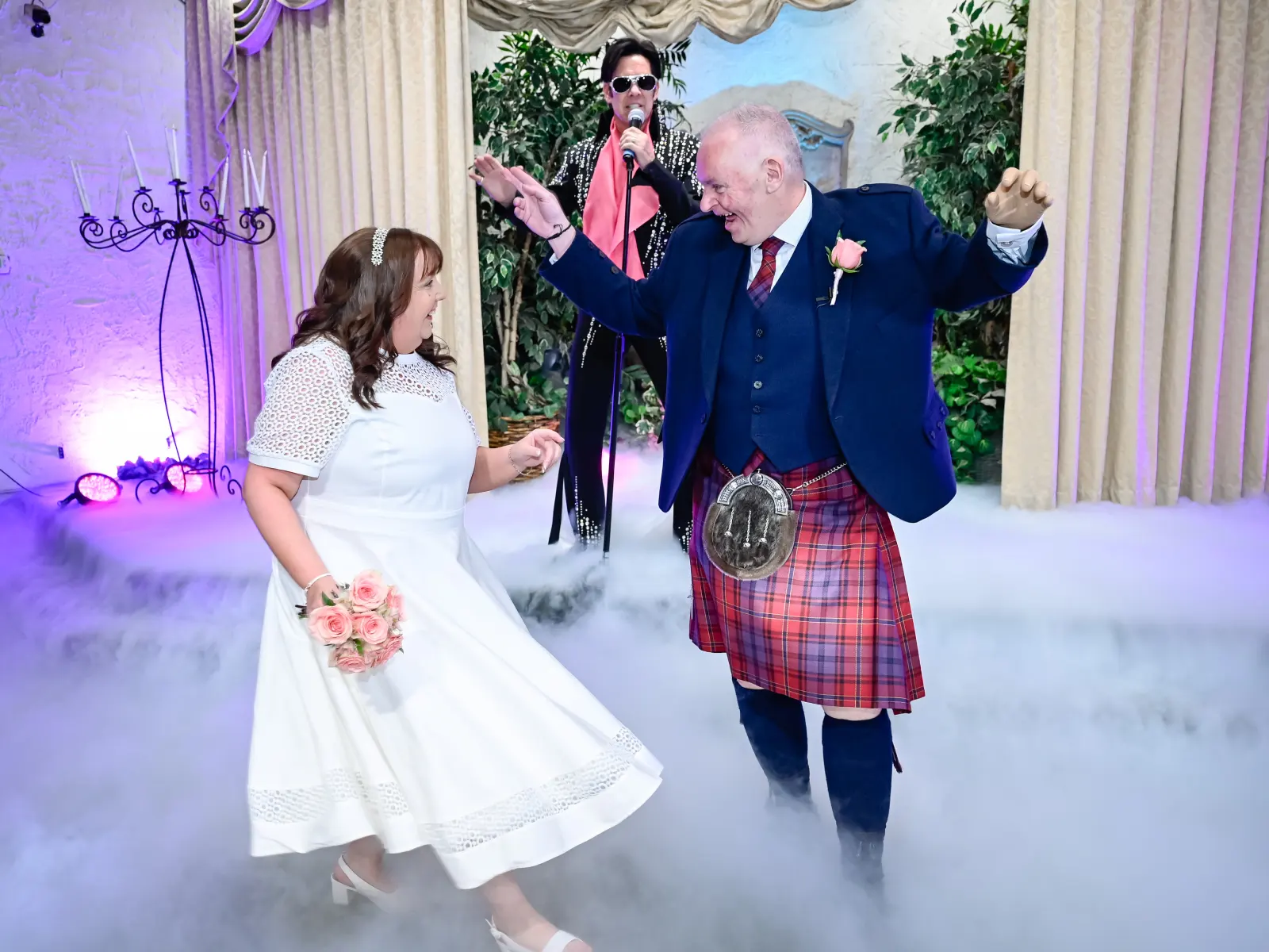 Las Vegas wedding couple first dance with Elvis impersonator in chapel ceremony surrounded by fog and romantic decor