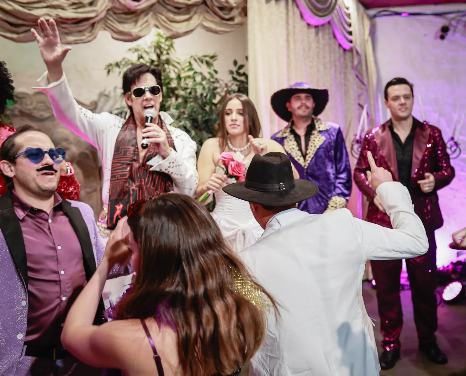 Wedding guests dancing in chapel as Elvis impersonator sings on stage