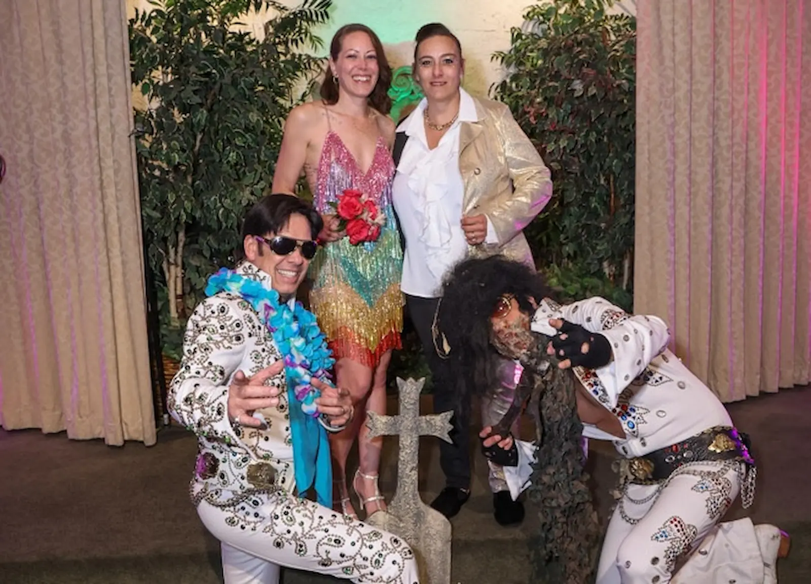 Two brides posing with Elvis and zombie Elvis impersonators at Viva Las Vegas Wedding Chapel