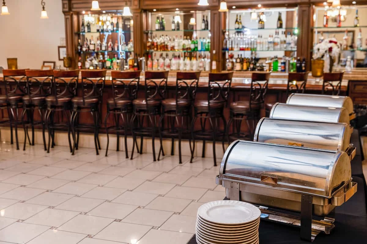 Catering buffet chafing dishes and full bar setup at Vegas Event Center reception venue