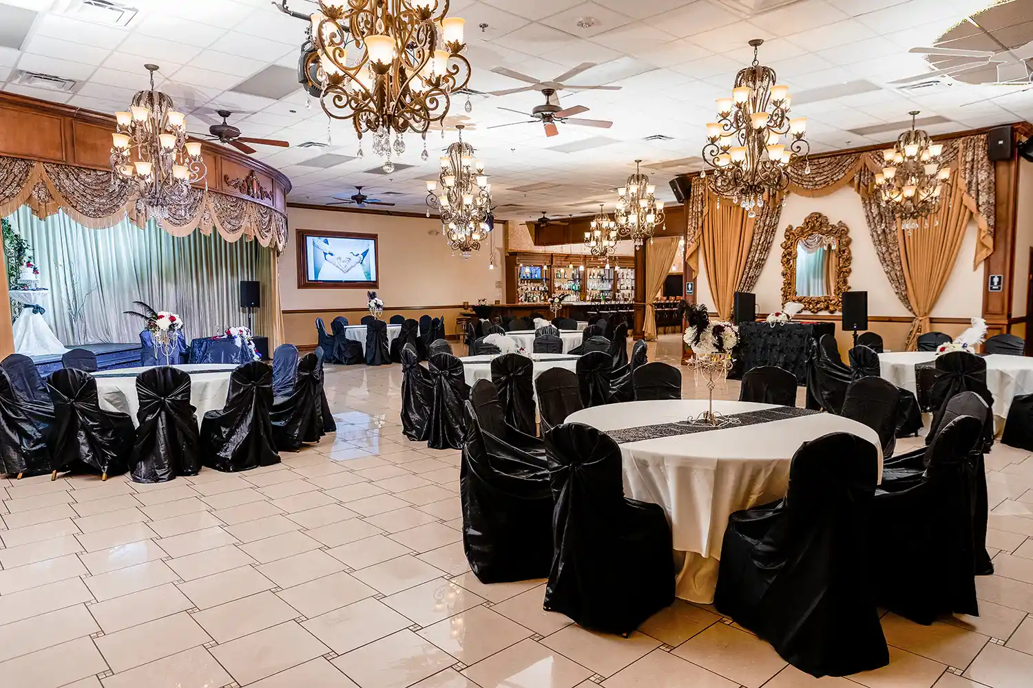 Vegas Event Center ballroom set up for wedding reception with black chair covers and crystal chandeliers