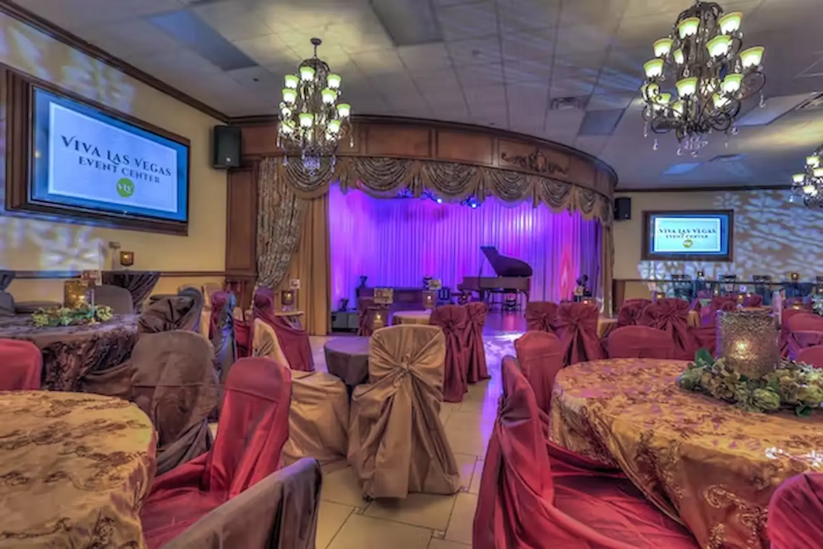 Viva Las Vegas Event Center banquet hall with purple stage lighting, grand piano, and red chair covers