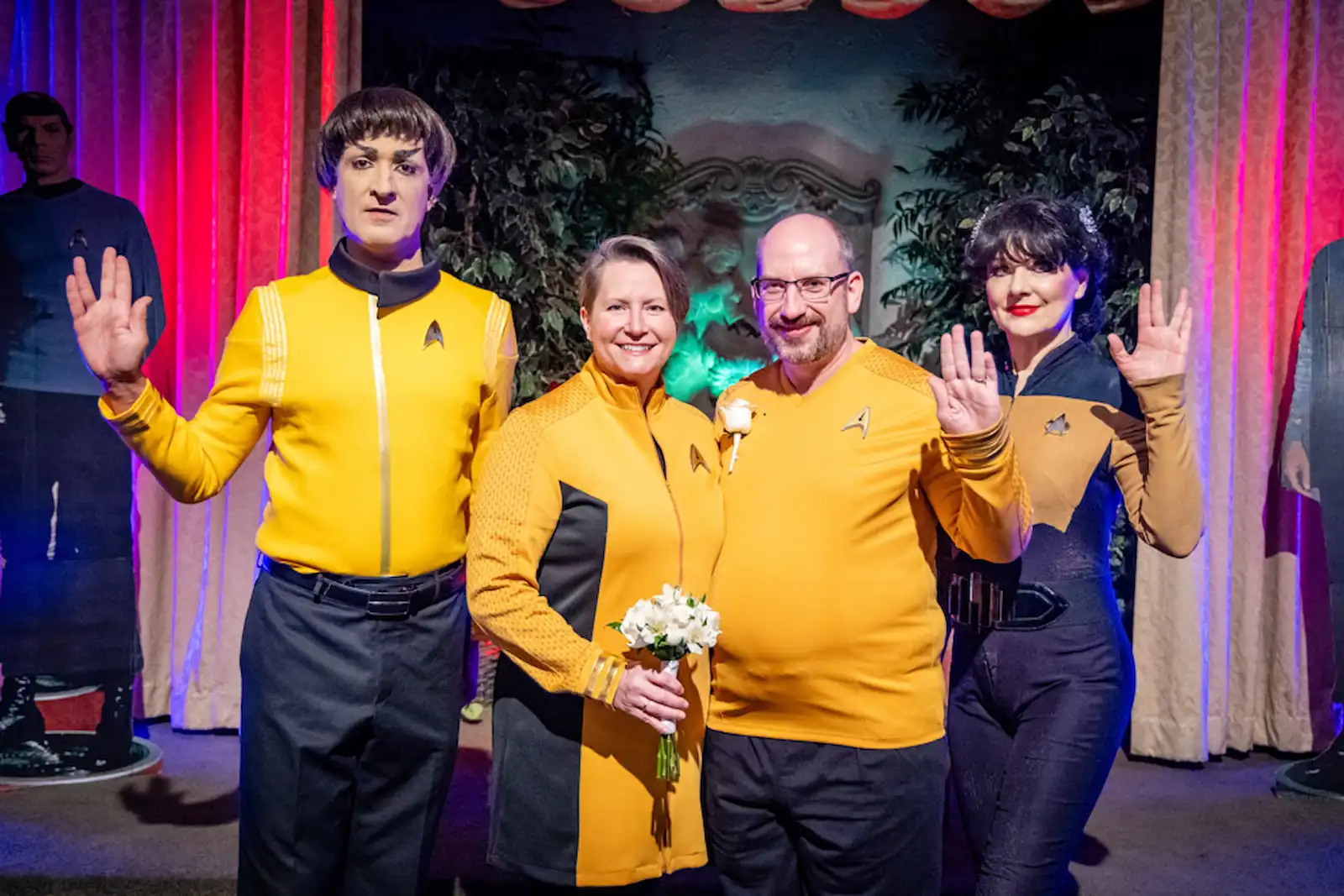 Newlywed couple in Starfleet uniforms posing with Spock and sci-fi impersonators doing Vulcan salute at Viva Las Vegas themed wedding