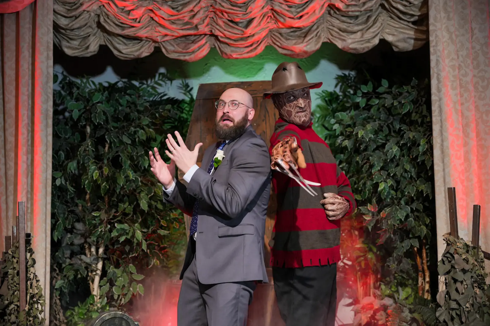 Startled groom with raised hands as Freddy Krueger looms behind him with razor claws at a Las Vegas wedding