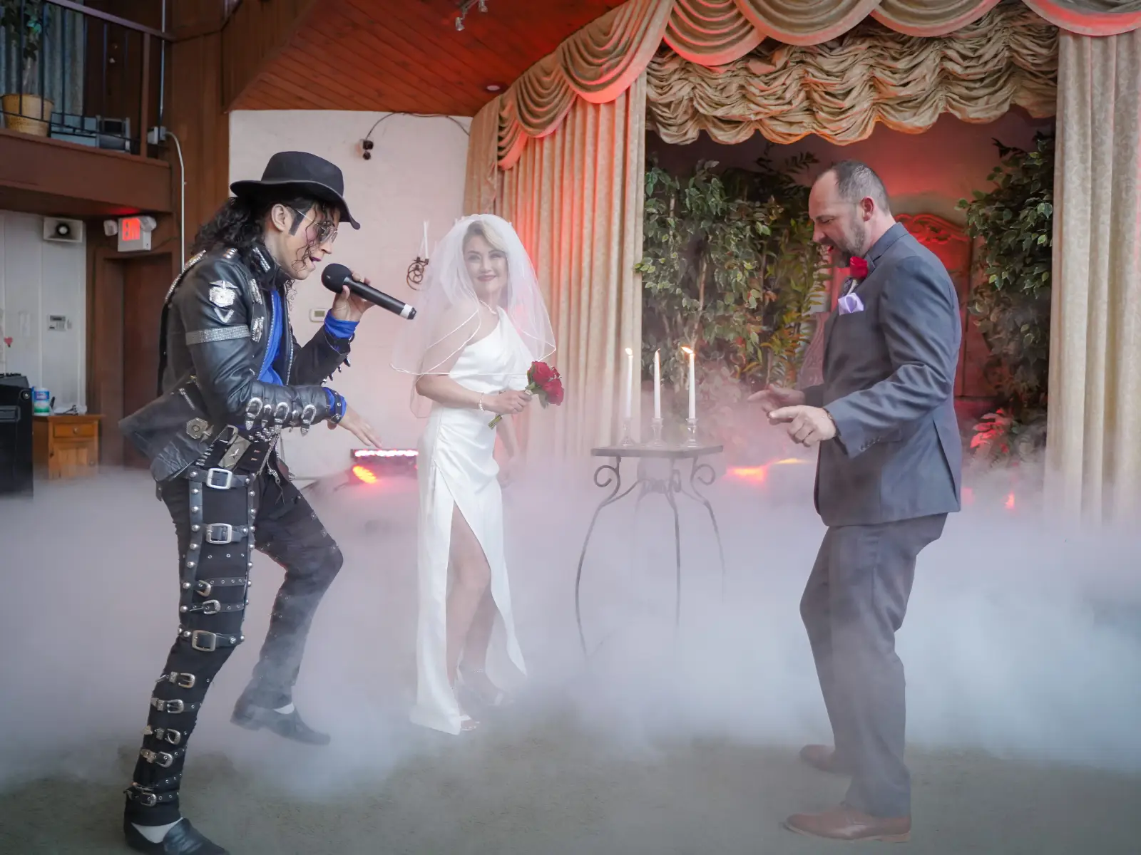 Michael Jackson impersonator in studded leather performing while bride and groom dance in fog-filled chapel