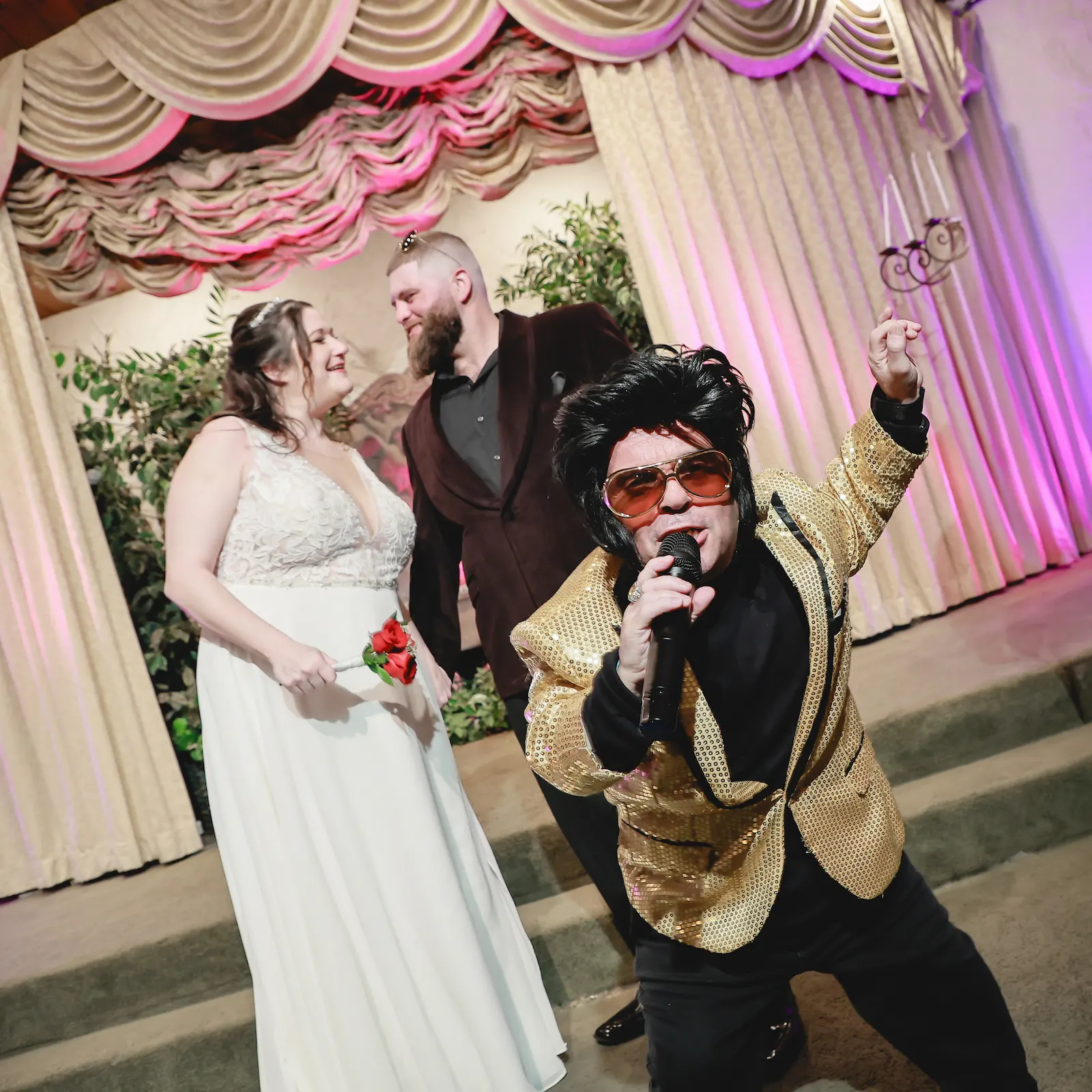 Mini Elvis in a gold sequin jacket serenades a smiling couple at their Vegas wedding ceremony
