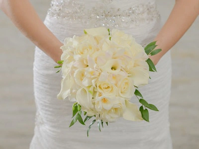 Elegant all-white bouquet of roses and calla lilies in a classic round shape