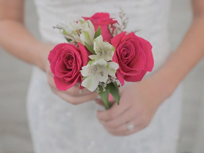 Hand-tied bouquet of three pink roses with white accent flowers