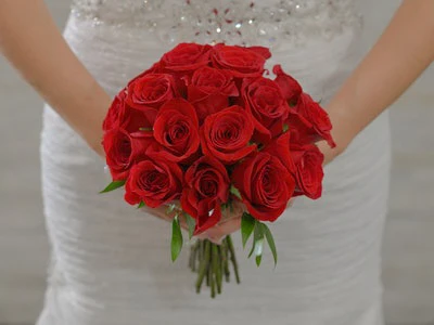  Bride holds a classic round bouquet of red roses