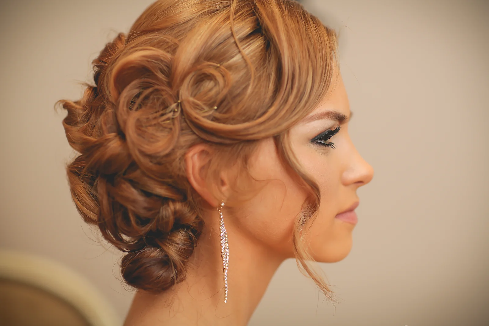 Bride with curled low bun updo and crystal drop earrings at a Las Vegas wedding chapel