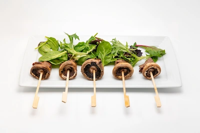 Garlic butter steak and mushroom skewers served over fresh greens
