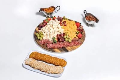 Charcuterie board with cheeses, salami, grapes, crackers, and nuts