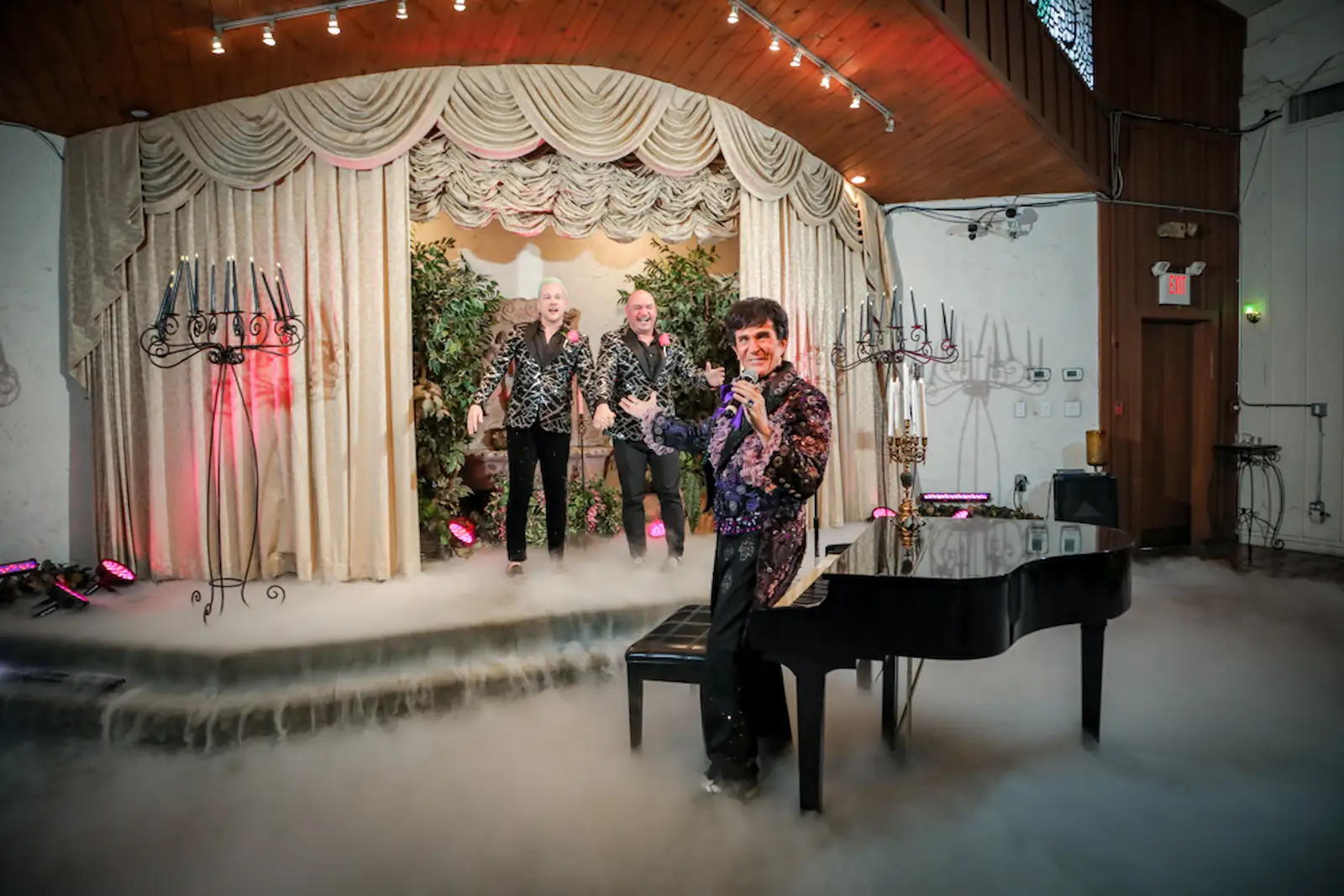 Liberace impersonator grand piano newlyweds matching blazers fog effects Las Vegas wedding