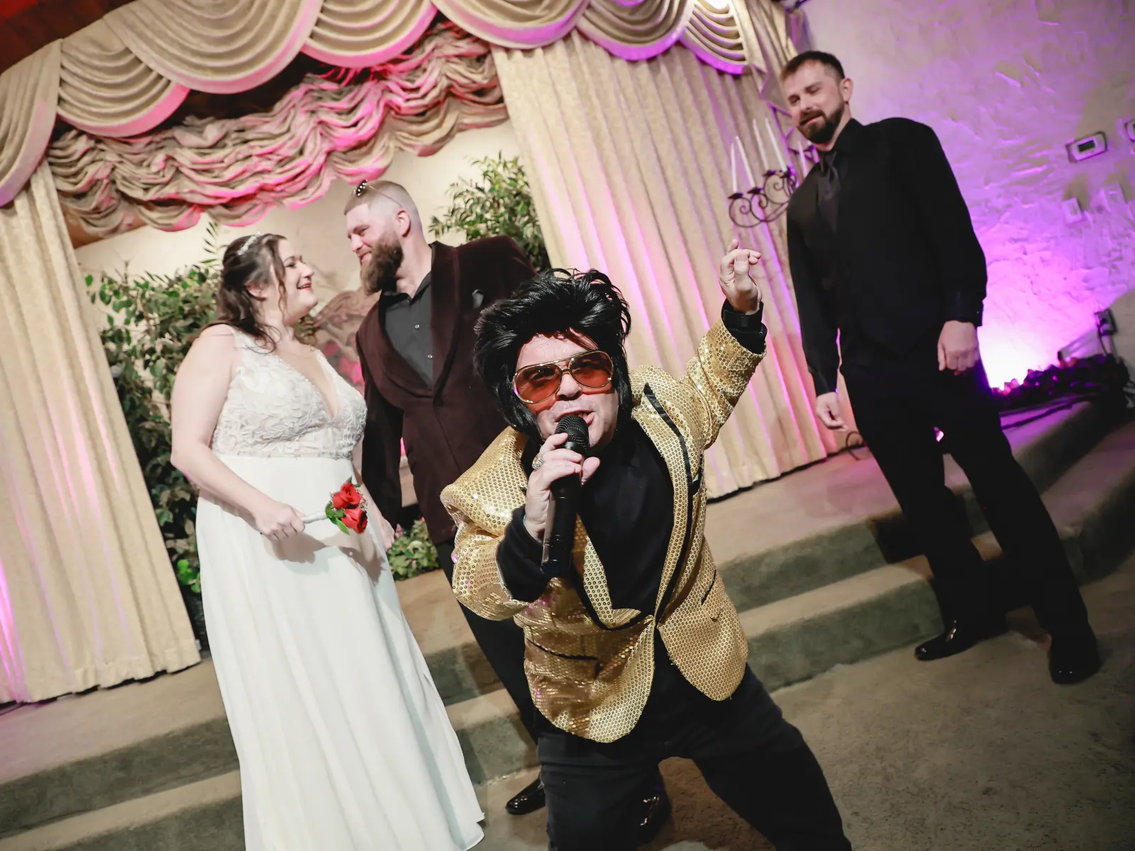 Fun Las Vegas Elvis wedding performance with energetic Elvis impersonator singing in front of bride and groom during lively chapel celebration