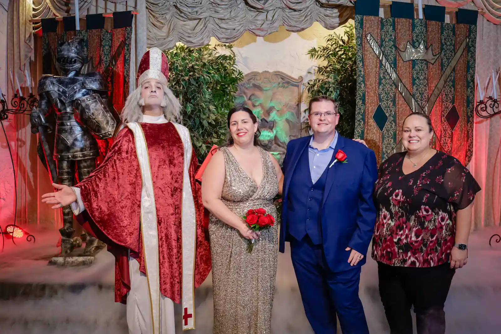 Wedding couple posing with medieval bishop officiant and knight armor at royal themed Las Vegas wedding chapel