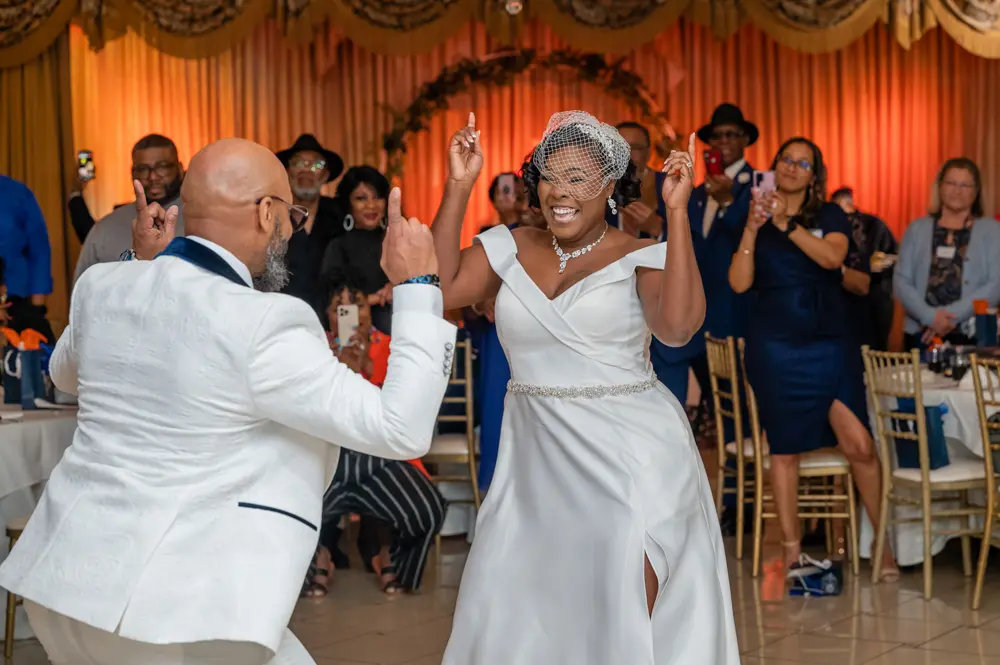 Bride and groom dancing joyfully at their Las Vegas wedding reception with guests cheering