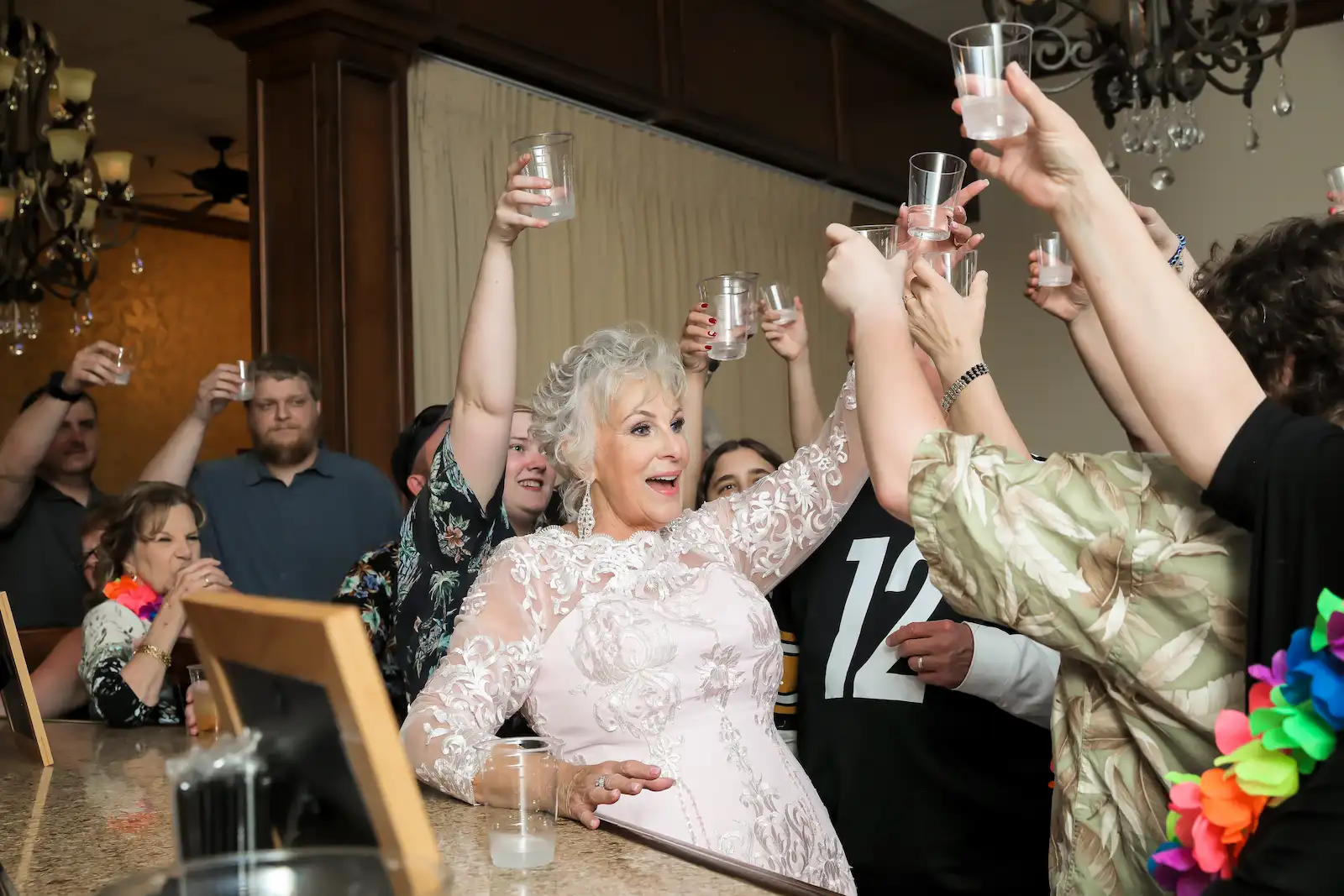 Bride raising shot glass with guests cheering at the bar during Vegas Event Center wedding reception