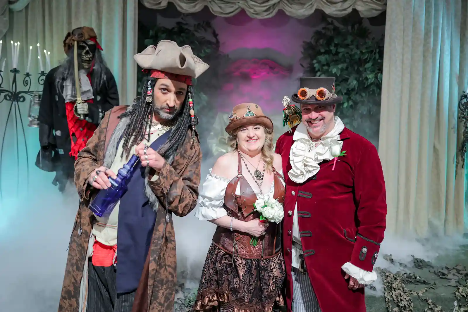Steampunk wedding couple posing with pirate officiant and stage fog at Las Vegas pirate themed wedding chapel