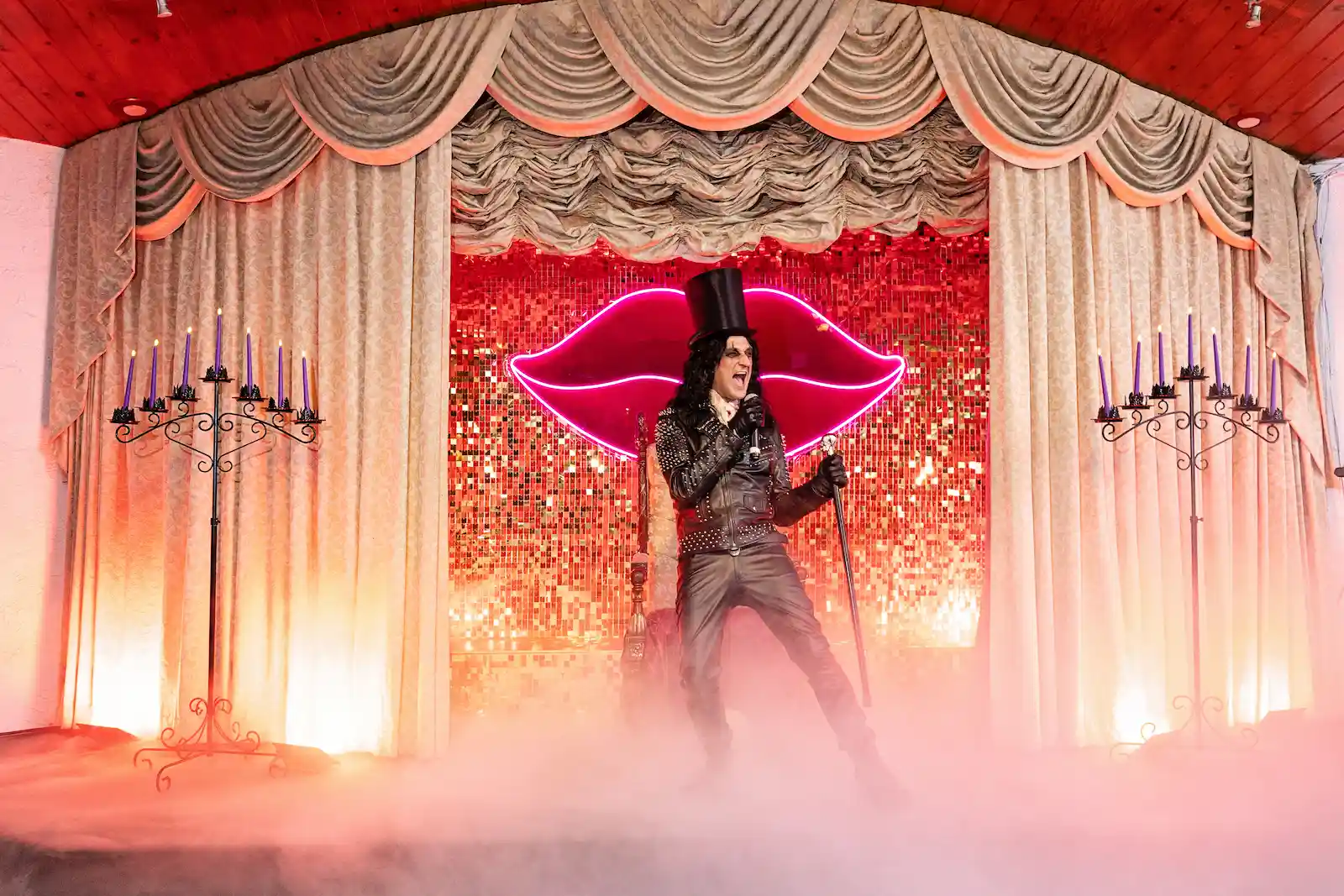 Alice Cooper impersonator performing on stage with fog and neon lips sign at a Las Vegas wedding chapel