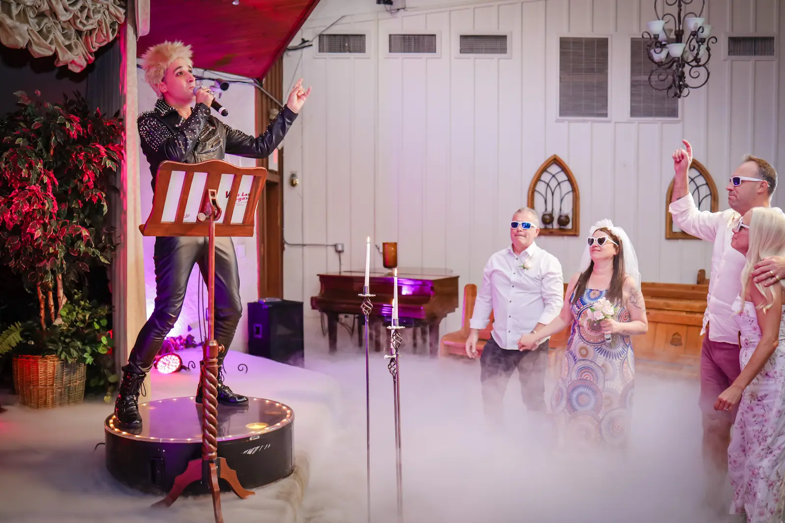 Billy Idol impersonator performing with dry ice fog during themed wedding ceremony at Viva Las Vegas Wedding Chapel