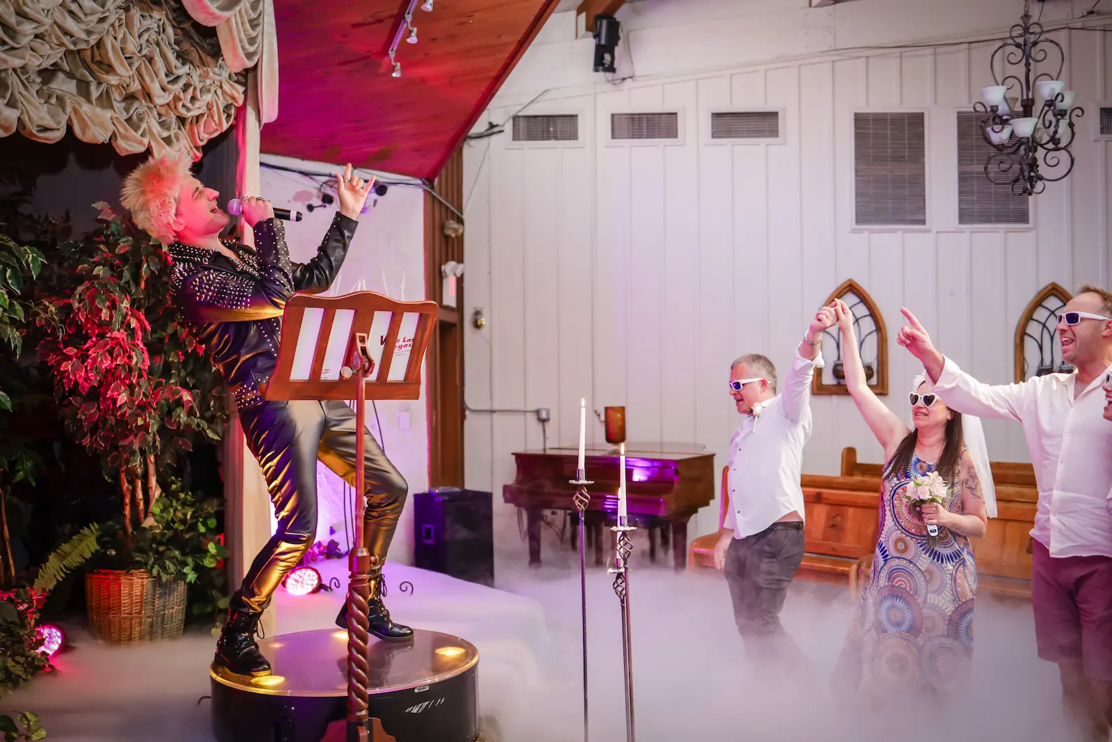 Billy Idol impersonator singing on stage while couple celebrates at Viva Las Vegas Wedding Chapel