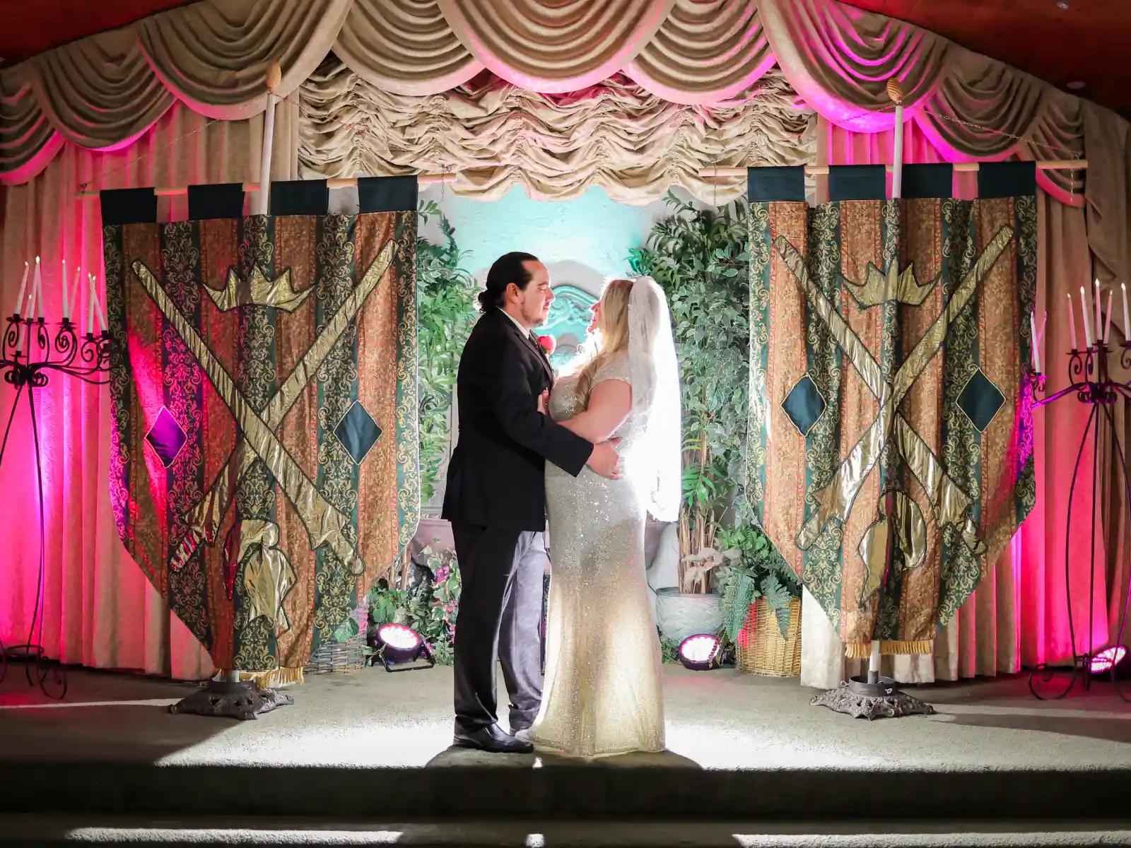 A bride and groom embracing at the altar in a fantasy-themed wedding chapel in Las Vegas.