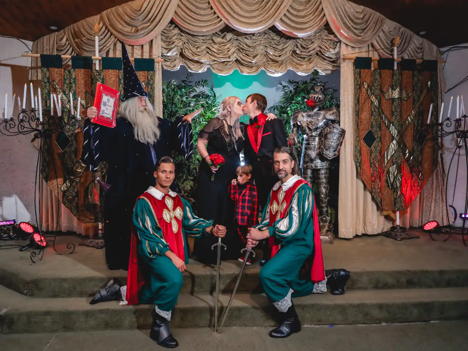A couple kissing at their fantasy-themed wedding in Las Vegas, joined by a wizard, knights, and a suit of armor.