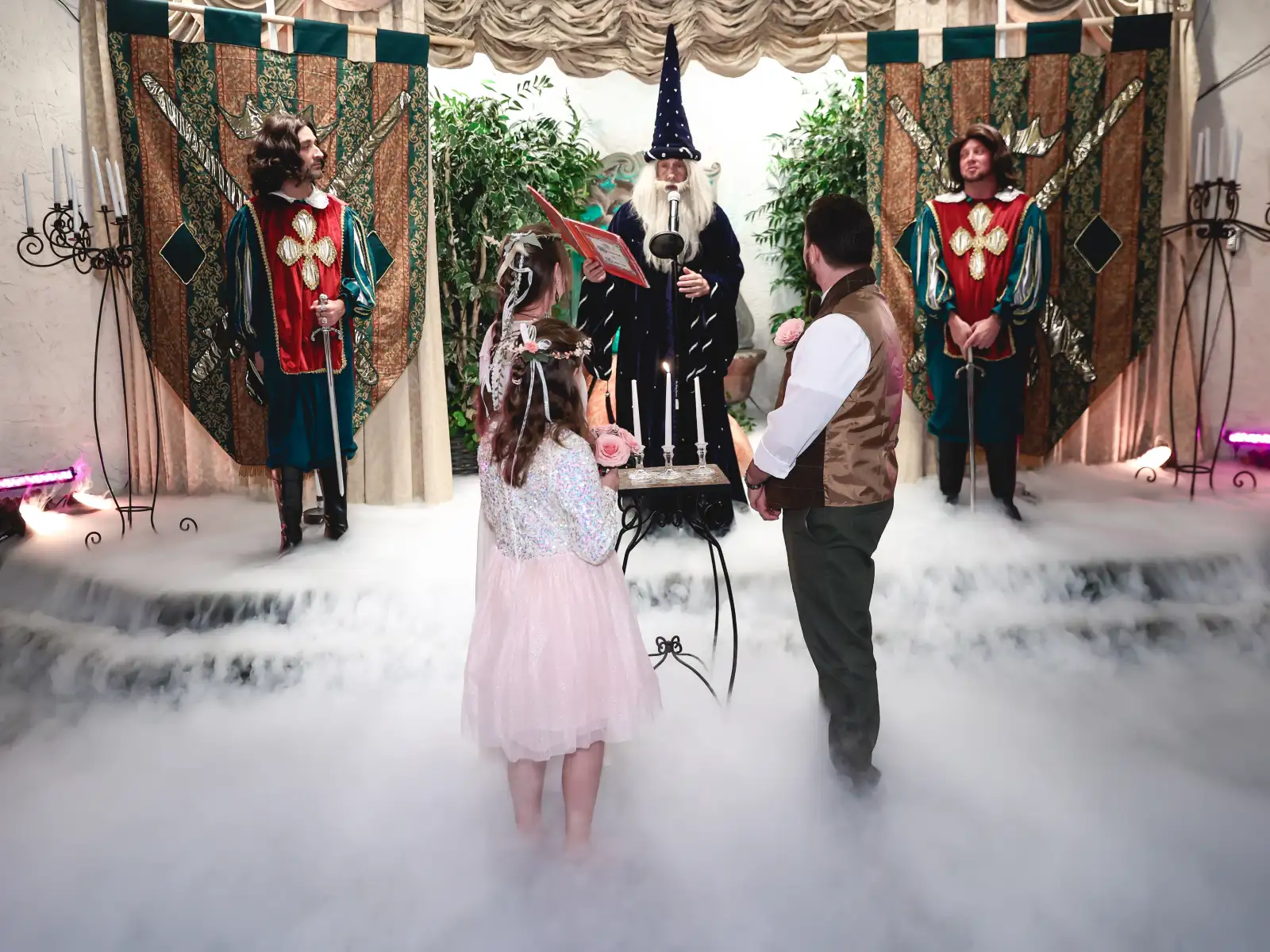A wedding ceremony in a Las Vegas themed chapel featuring a wizard officiant, knights, and a couple standing in magical fog.