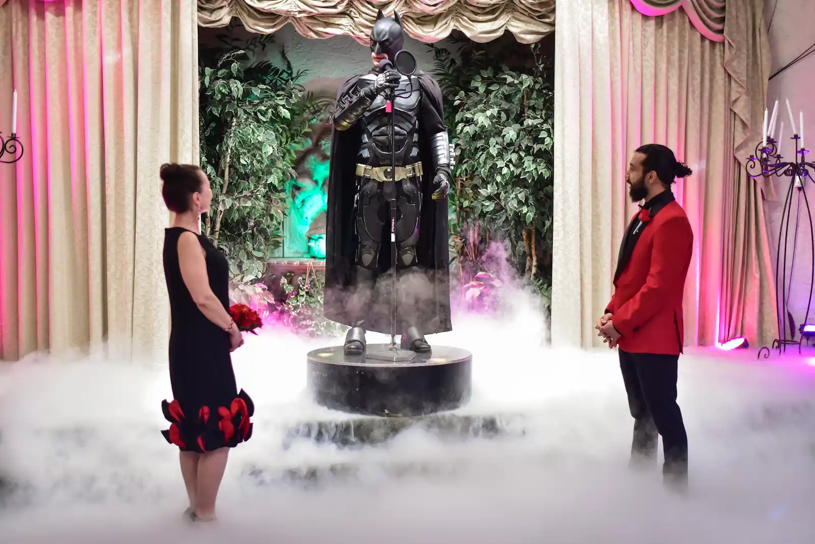 Couple exchanging vows with Batman costumed officiant and dry ice fog at Viva Las Vegas Wedding Chapel