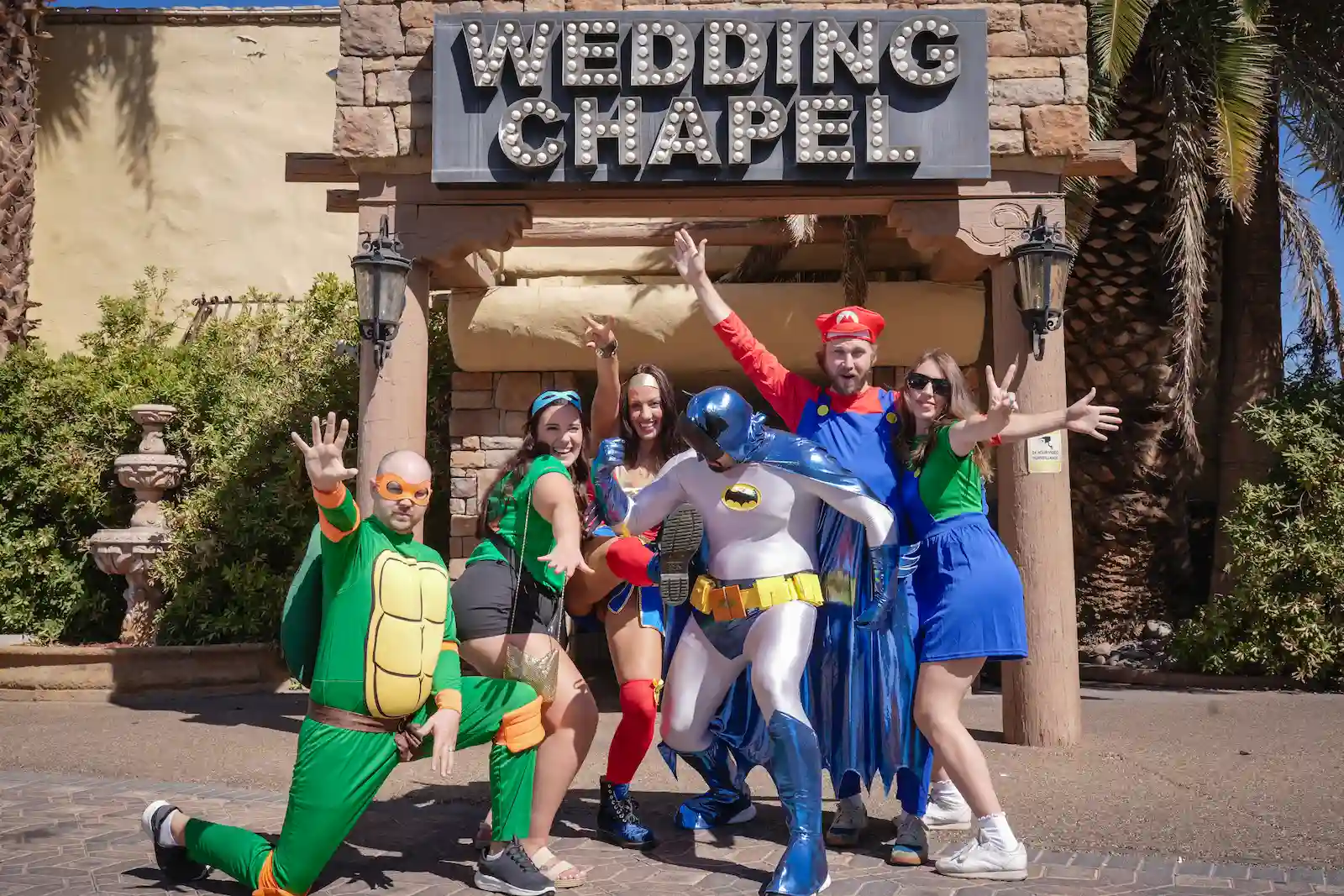 Wedding party in superhero and video game costumes posing outside Viva Las Vegas Wedding Chapel