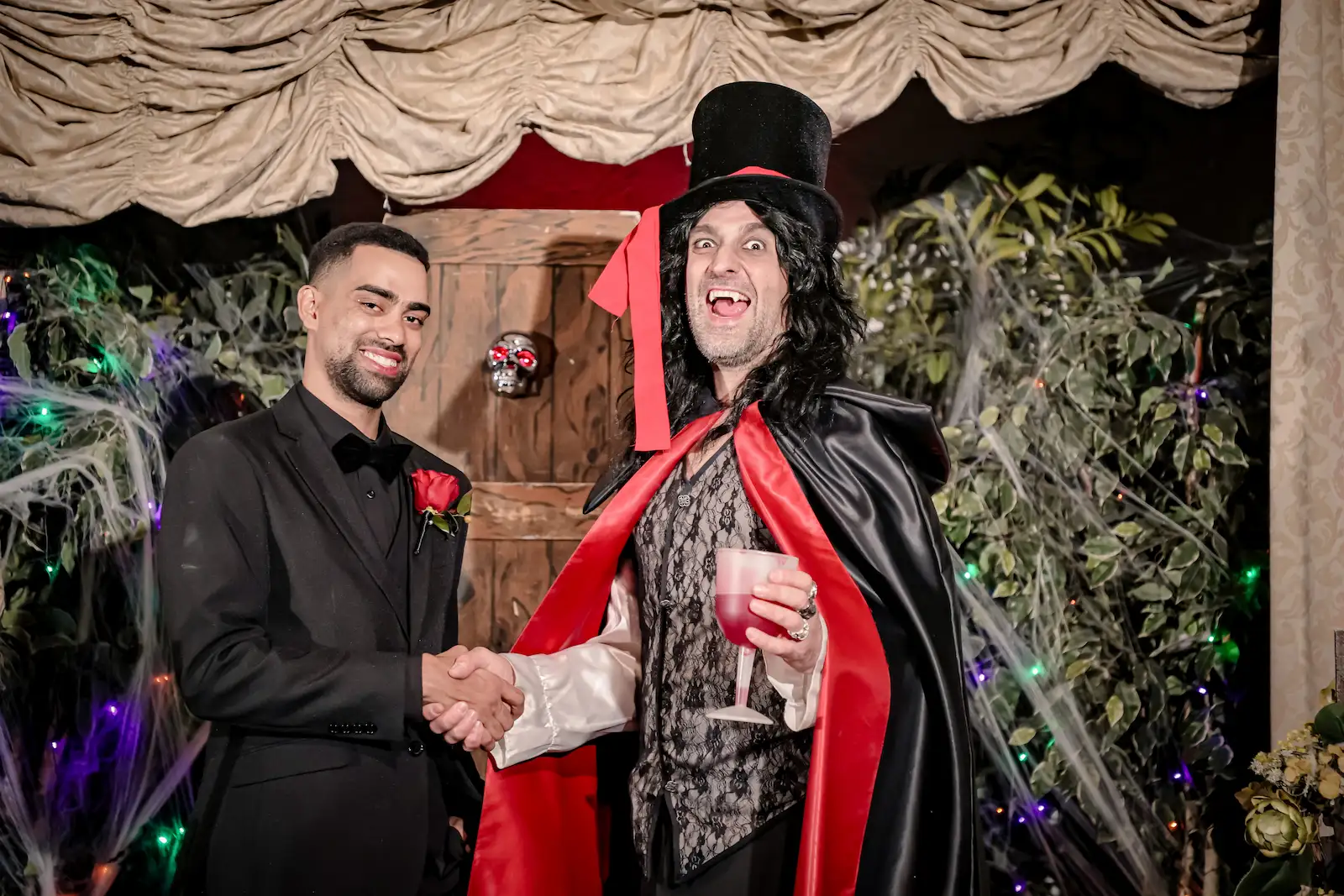 Groom shaking hands with a vampire officiant at a Las Vegas halloween wedding venue.