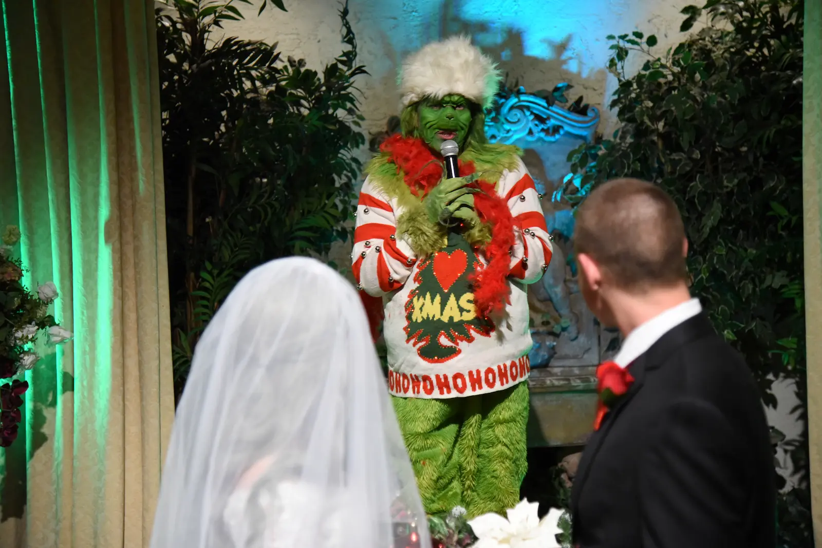 Grinch character in ugly Christmas sweater officiates wedding ceremony for bride and groom at Las Vegas chapel