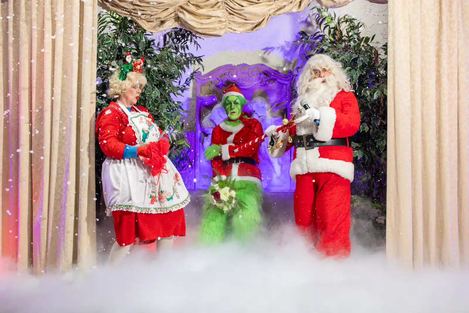 Santa Mrs. Claus and Grinch characters perform on fog-filled stage during Christmas wedding at Las Vegas chapel