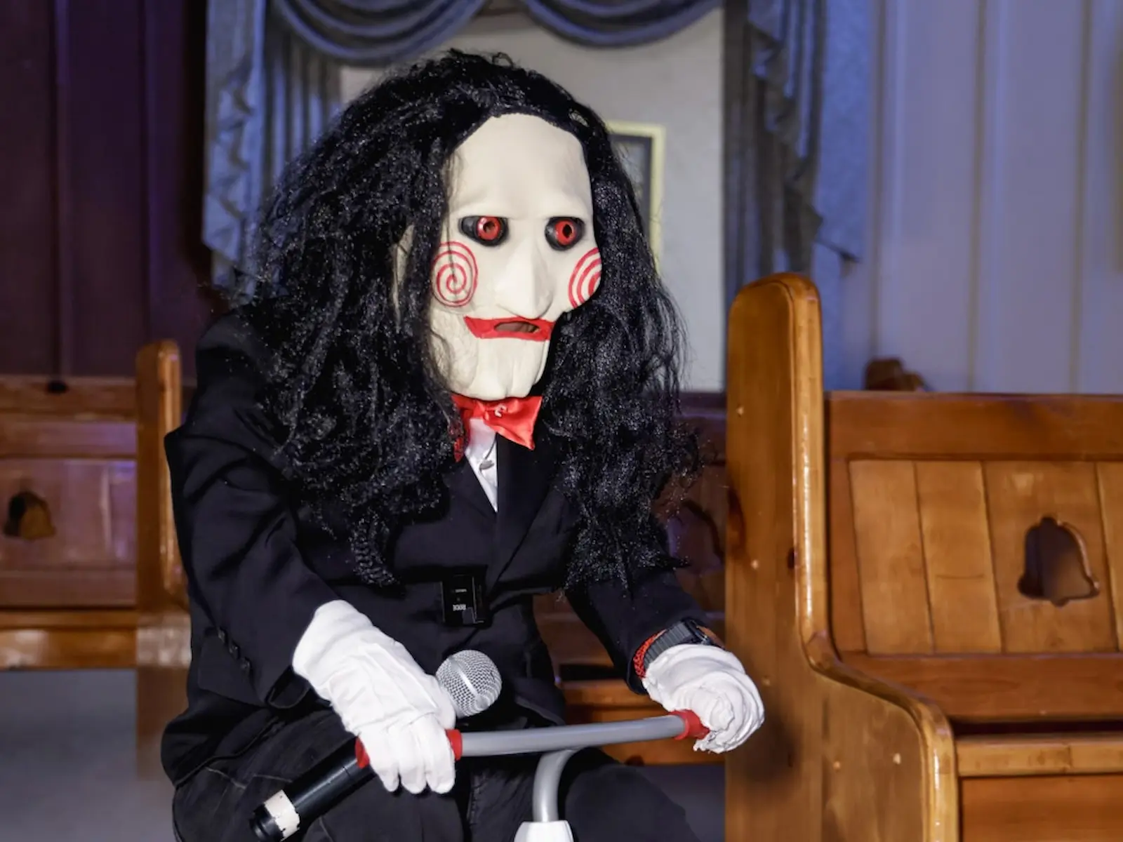 Closeup of Saw Billy puppet on red tricycle during horror themed wedding at Viva Las Vegas Wedding Chapel