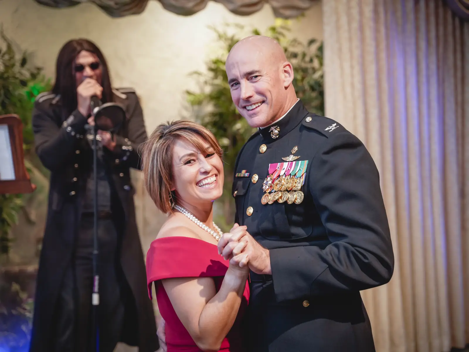 Couple shares their first dance during a Las Vegas gothic wedding while the themed officiant sings in the background.