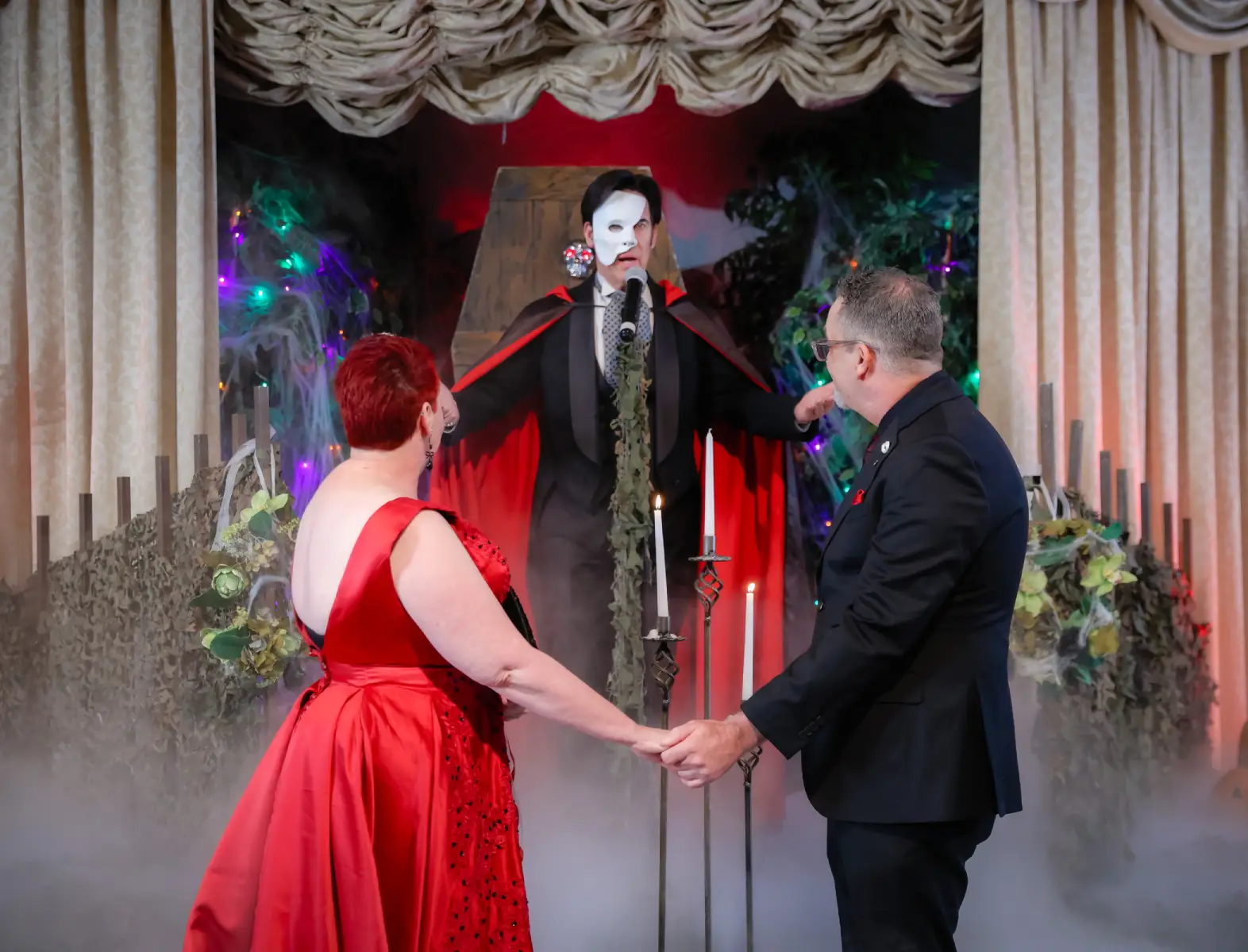 phantom themed wedding ceremony with couple holding hands in gothic halloween chapel