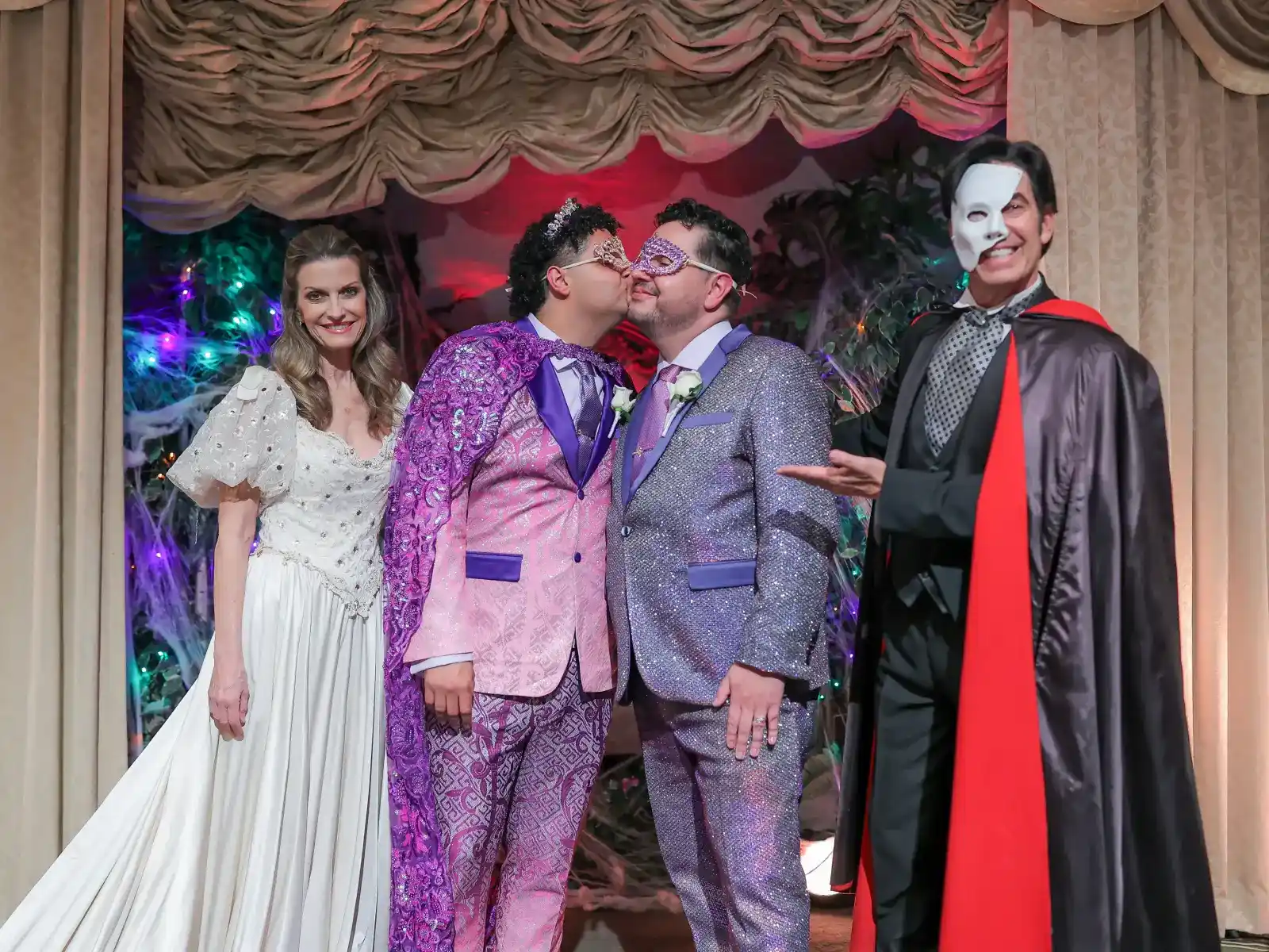 couple kissing wearing masquerade masks at phantom themed wedding ceremony