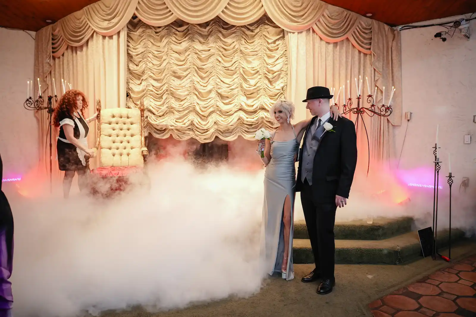 Newlyweds pose together surrounded by dramatic dry ice fog during Rocky Horror themed wedding at Las Vegas chapel