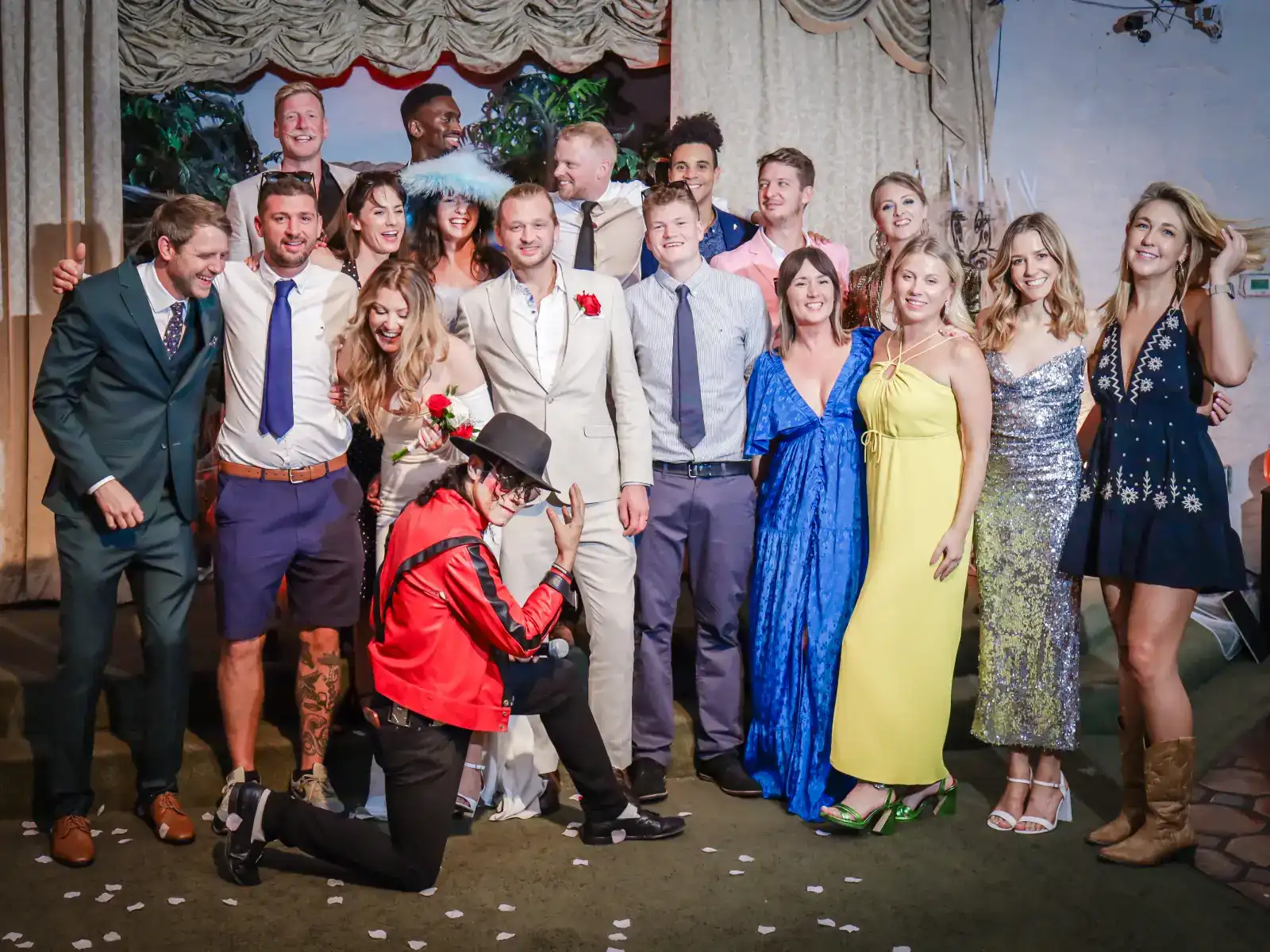 wedding party group photo with bride and groom celebrating at ceremony stage