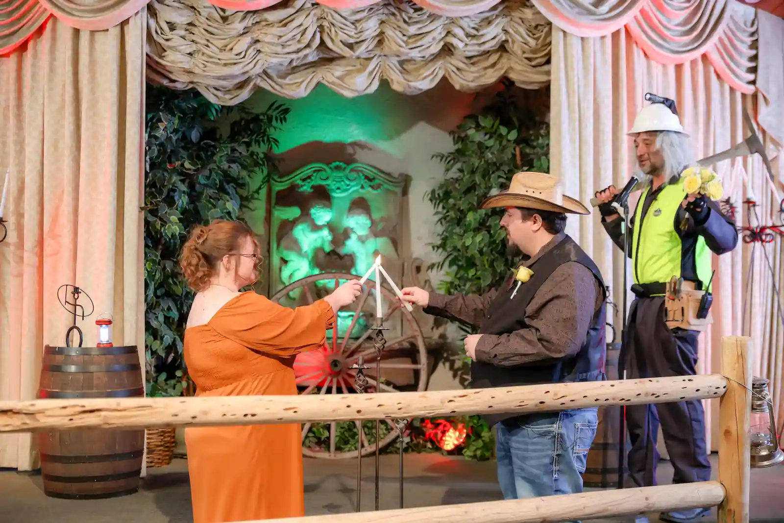 Couple in western outfits lights unity candle during cowboy themed wedding ceremony at Las Vegas saloon chapel