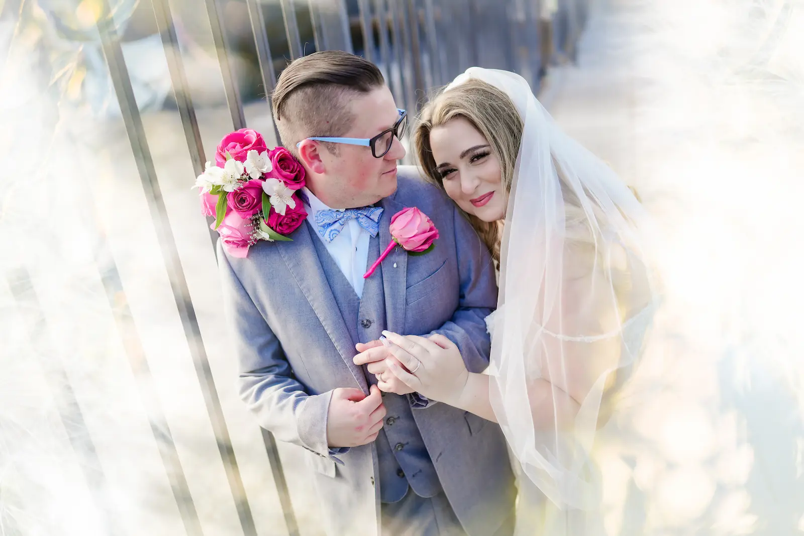 Bride leaning on groom holding a vibrant pink bouquet at Viva Las Vegas Wedding Chapel.