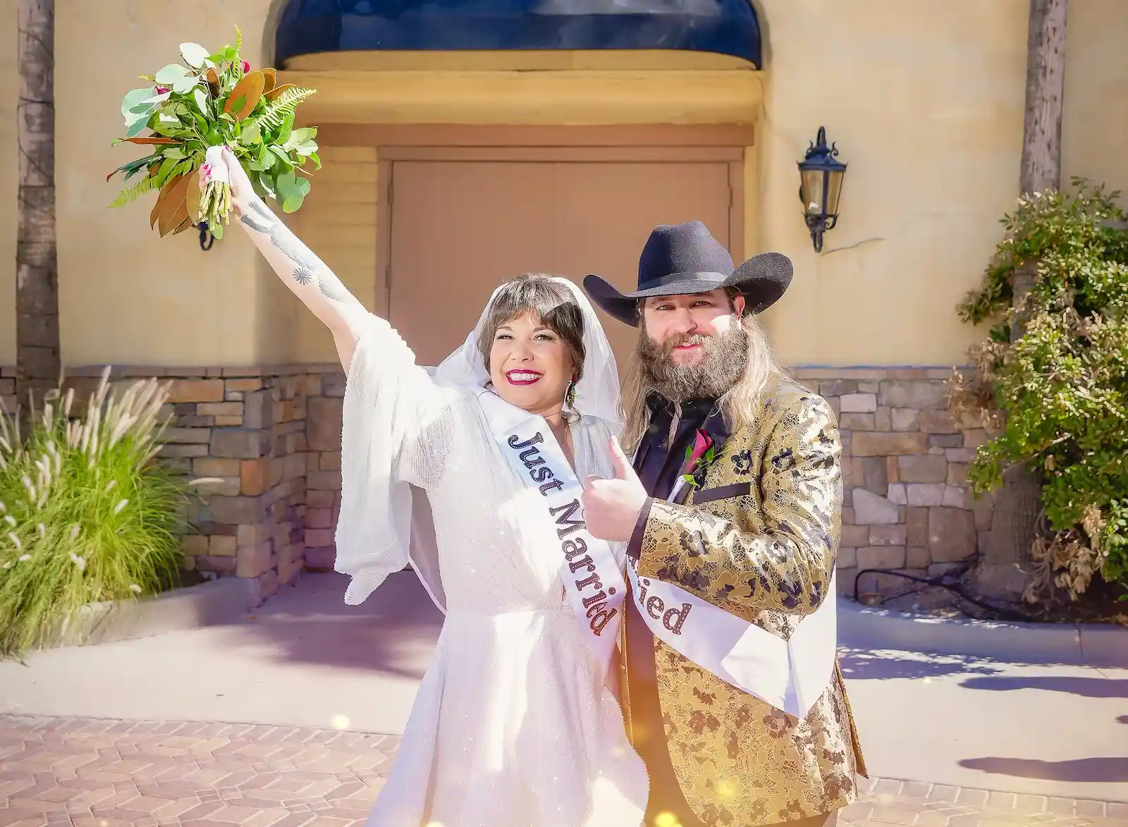 Just married couple celebrating outside Las Vegas wedding chapel with bouquet raised