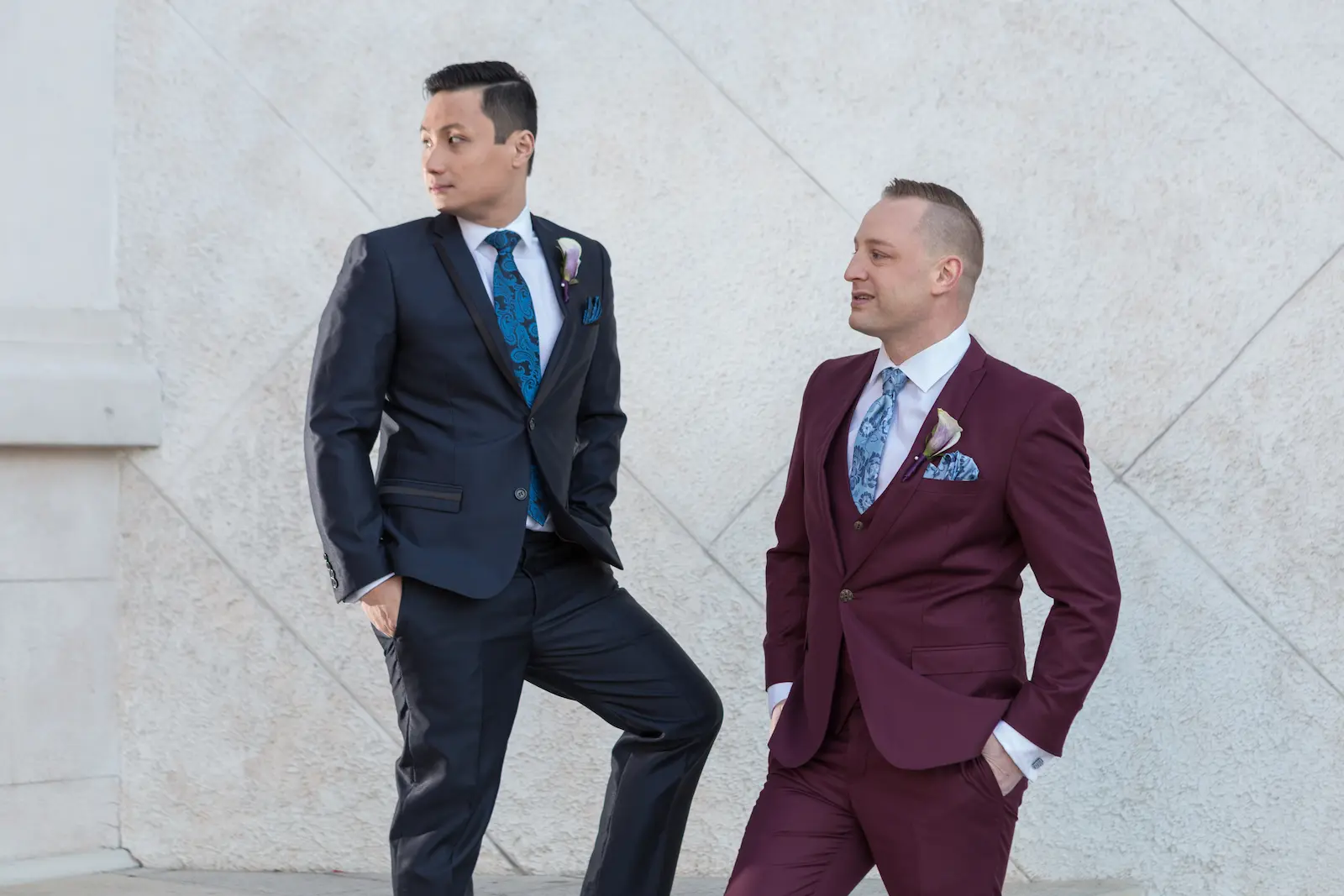 Two grooms in modern suits posing together during a stylish Las Vegas wedding