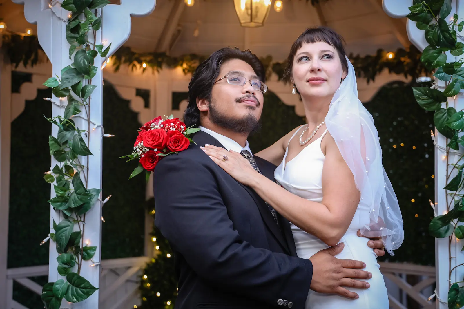 Bride and groom embracing inside the fairy-lit gazebo at Viva Las Vegas Wedding Chapel.
