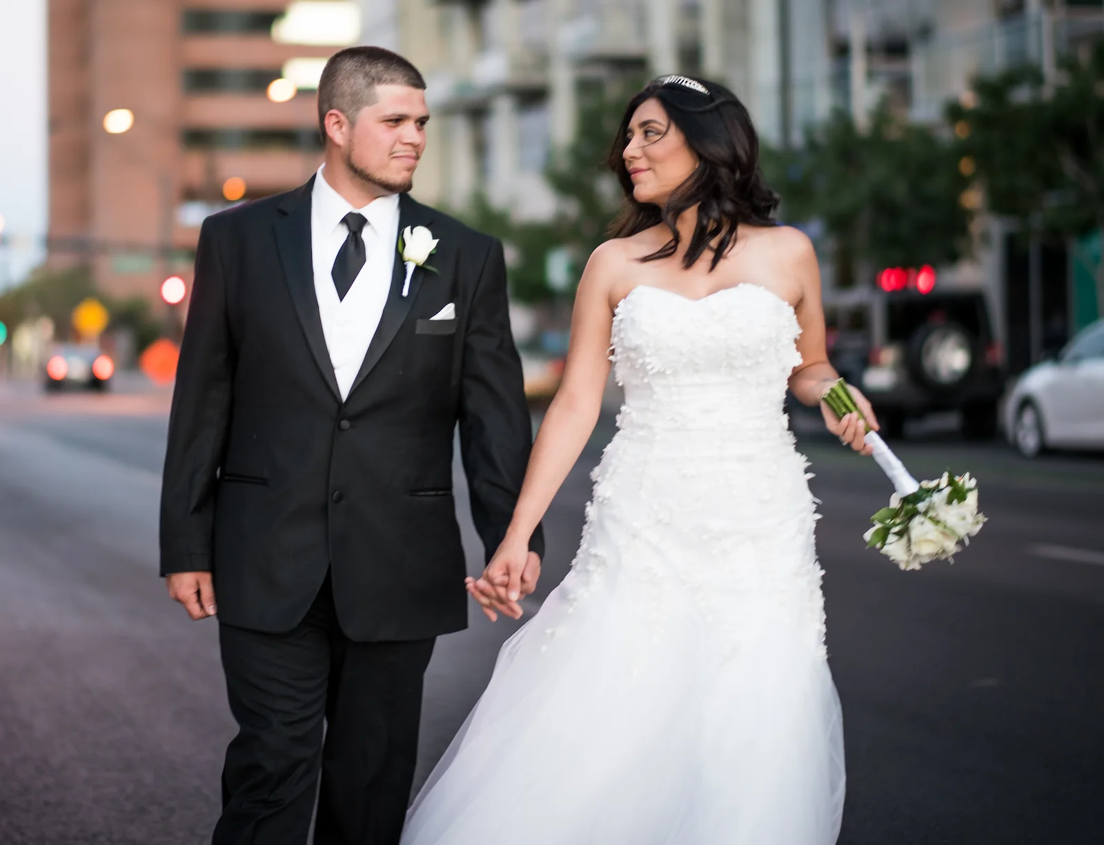 Couple walking downtown Las Vegas wearing rental tux and wedding gown